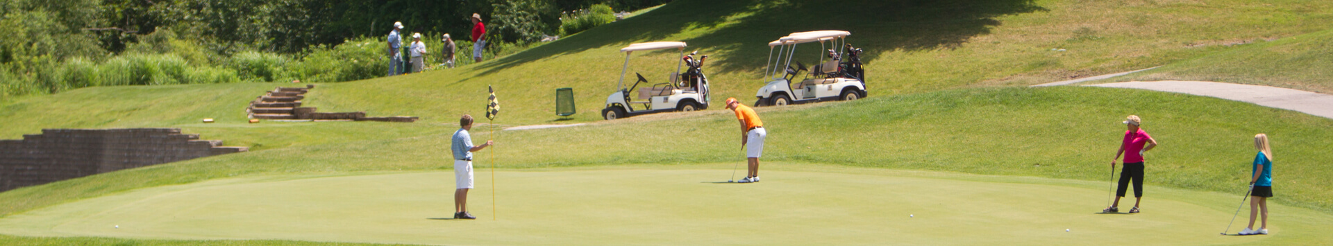 Several golfers on the green with another group waiting to play