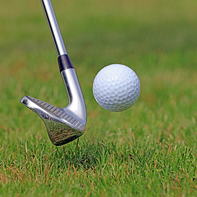 Golf ball being hit with club